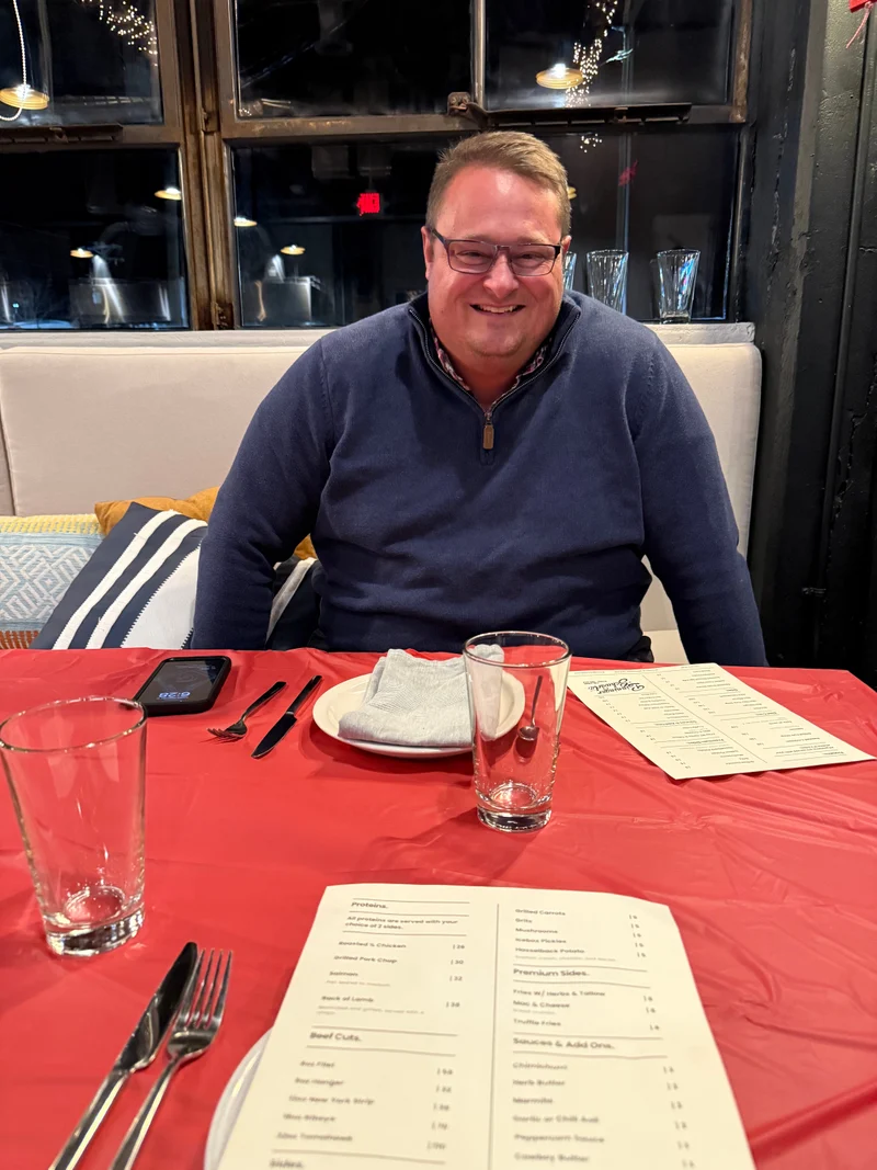 Daniel smiling at a restaurant table