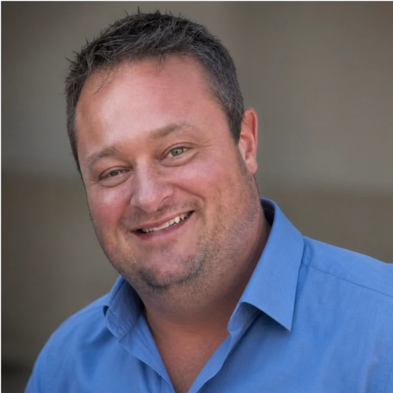 Daniel Berry smiling in a blue collared shirt